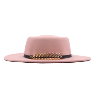 Nahaufnahme des rosa Wollfilzhutes mit schicker goldener Metallfischgräte und schwarzem Gürtel.