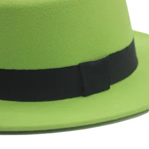 Grüner Wollfilz Fedora Hut Detail, schwarzes Band, quadratischer Knoten, britischer Retro-Stil.