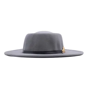 Grauer flacher Wollhut für Damen mit schwarzem Lederband und goldenem Metallmedaillon.