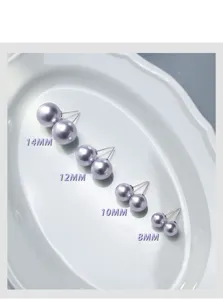 Gros plan de boucles d'oreilles perles violettes de tailles variees sur assiette.