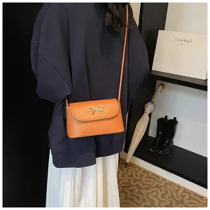 Stylish women crossbody bag with metal bow accent, trendy orange shoulder bag for daily wear.