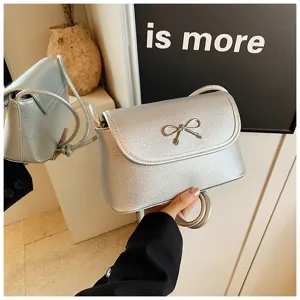 Silver metallic crossbody bag for women, trendy underarm baguette bag with cute bow detail.