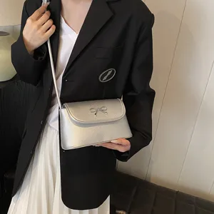 Silver metallic crossbody bag for women, stylish bowknot underarm shoulder bag for daily use.