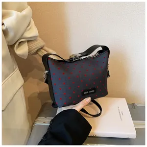 Women's stylish small shoulder bag with red heart pattern and metal lock detail for daily wear.