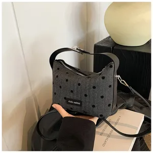 Close-up detail of stylish casual women shoulder bag with polka dots and bow decor.
