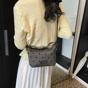 Trendy women's crossbody bag with playful polka dots and cute bows for casual daily wear.