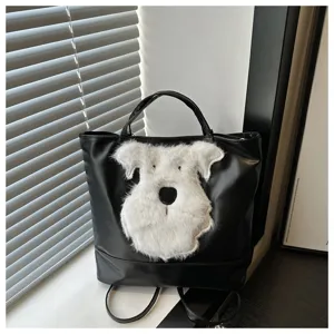 Detail van de zwarte lederen tas met een schattige pluizige puppy opdruk en mooi design.