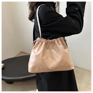 Detail shot of a soft leather shoulder bag with drawstring closure and bow accent.