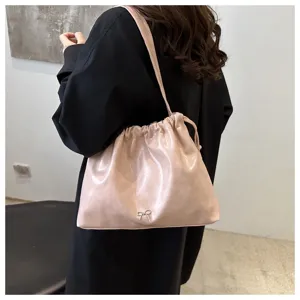 Chic pink soft leather shoulder bag with drawstring closure and cute bow detail for women.