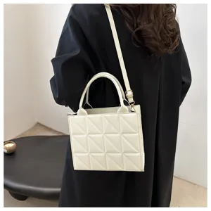 Detailed view of the elegant white quilted small square handbag with adjustable strap.