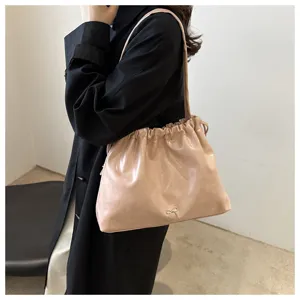 Detailed view of women soft leather shoulder bag, chic bow knot accent and bucket design.