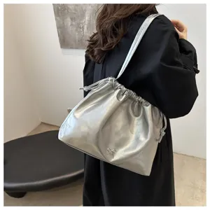 Stylish silver soft leather shoulder bucket bag with drawstring closure and chic bow detail.