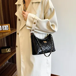 Stylish black quilted chain shoulder bag worn by a model, showcasing trendy dumpling hobo design.