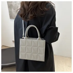 Detailed view of grey quilted leather handbag, stylish shoulder crossbody bag for women.