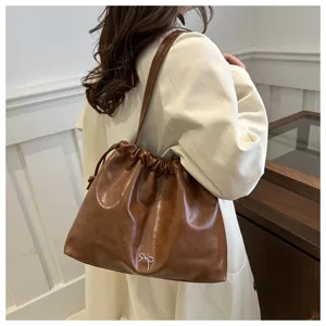 Brown soft leather shoulder bucket bag detail, stylish daily commute cross-body handbag.