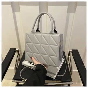 Grey quilted tote bag for women, stylish structured handbag with top handle and crossbody strap.
