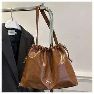 Brown soft leather drawstring shoulder bag detail, elegant casual daily wear accessory.