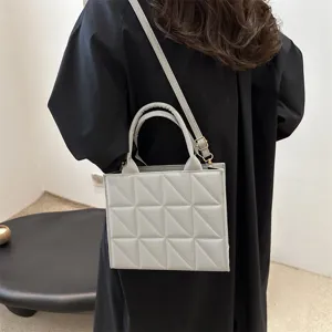 Stylish grey quilted shoulder bag for women, featuring geometric stitching and top handle.
