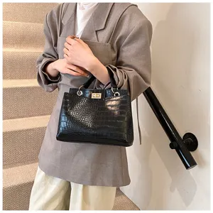 Vista dettagliata di una elegante borsa a tracolla nera coccodrillo con chiusura.