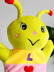 Primo piano dettagliato della simpatica marionetta peluche bruco con cuore ricamato.
