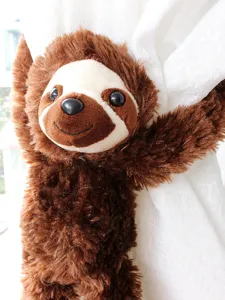Sloth plush toy curtain tieback detail shot, cute brown hanging long arm plush doll.