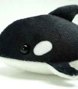 Killer whale plush toy detail shot, cute orca stuffed animal, soft marine animal doll for kids.