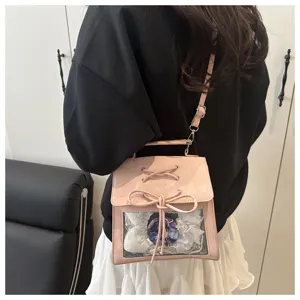 Vue détaillée d'un sac ita rose mignon avec fenêtre transparente, nœud papillon et bretelles.