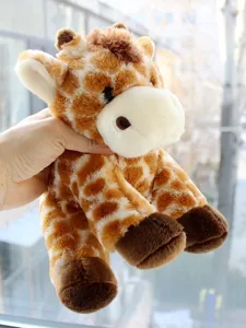 Vue en gros plan détaillée d'une adorable peluche girafe assise aux douces taches.