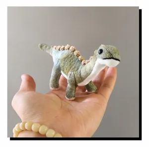 Nahaufnahme eines kleinen Dinosaurier Plüschtiers, das weiche Textur und Design zeigt.