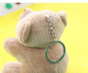 Gros plan détaillé d'un mignon petit porte-clés en peluche ours marron avec un anneau métallique.