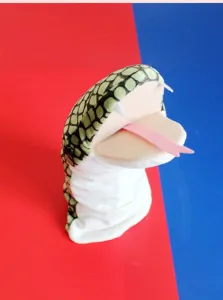 Dettaglio burattino a mano serpente di peluche, morbido tessuto verde e bocca mobile.