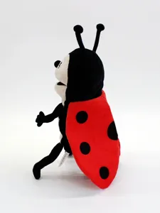 Vue en gros plan du détail de la marionnette coccinelle en peluche avec une bouche ouverte et douce.