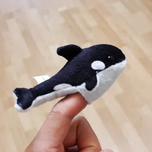 Detailed view of cute killer whale plush finger puppet, soft fabric, ideal interactive toy.