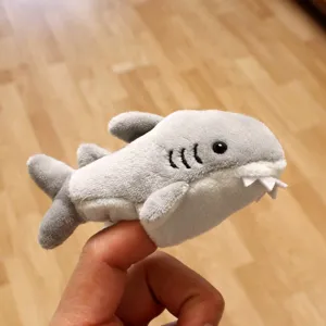 Plush shark finger puppet detail shot, soft material, cute animal toy for kids interaction.