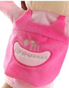 Vista dettagliata di un pupazzo a mano in peluche rosa con grembiule ricamato.