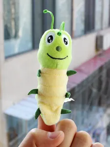 Gros plan détaillé d'une jolie marionnette à doigt chenille verte avec un tissu doux.