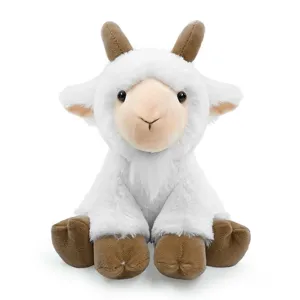 Gros plan d'une jolie peluche de chèvre assise avec de la fourrure blanche et des cornes.