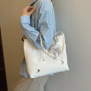 Chic white canvas tote bag for women, large capacity with braided strap and cute cloud charm.