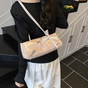 Chic elongated shoulder underarm bag for women, featuring elegant metallic bows and pearl lace.