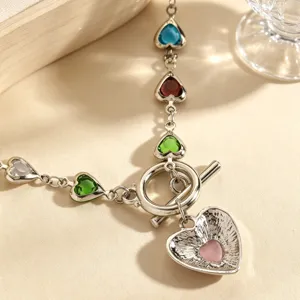 Close-up detail of silver-tone chain necklace with colorful heart crystal pendants.