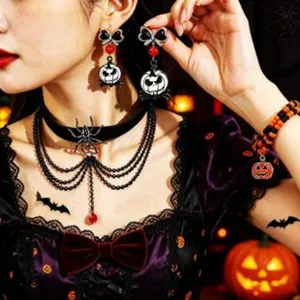 Halloween theme jewelry detail shot featuring skeleton pumpkin earrings and spider choker necklace.