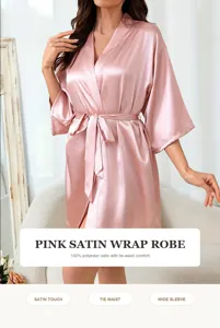 Detailopname van een roze satijnen badjas met zachte stof en elegante strikceintuur.