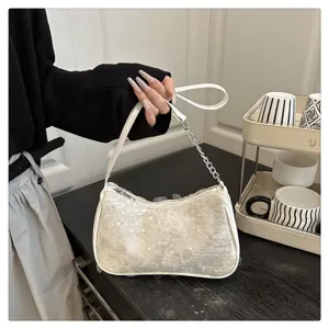 Close-up of white sequin shoulder bag with chain strap, sparkling texture and stylish design.