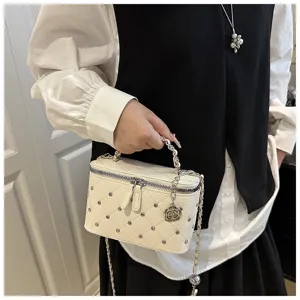 Sac bandoulière matelassé tendance avec rivets, chaîne et charmant pendentif floral.