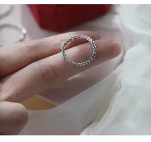Primo piano dettaglio dell'anello morbido scintillante in argento, design minimalista.