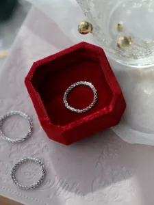 Anello impilabile scintillante in argento delicato, primo piano dettagliato con texture brillante.