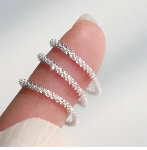 Primer plano detallado de anillos de plata apilados, textura brillante para estilo femenino.