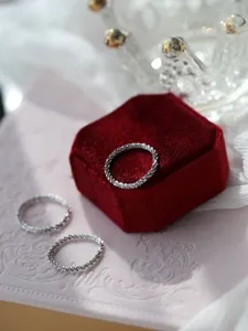 Scatto di dettaglio di anelli scintillanti in argento sterling, delicata trama e stile chic.
