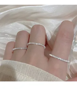 Primer plano detallado de anillos de plata brillantes usados elegantemente en los dedos.