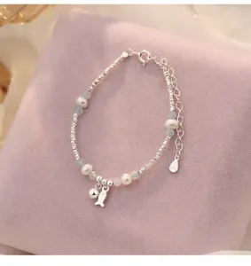 Nahaufnahme des S925 Silber Perlenarmbands mit süßem Fisch-Anhänger, feines Schmuckdetail.